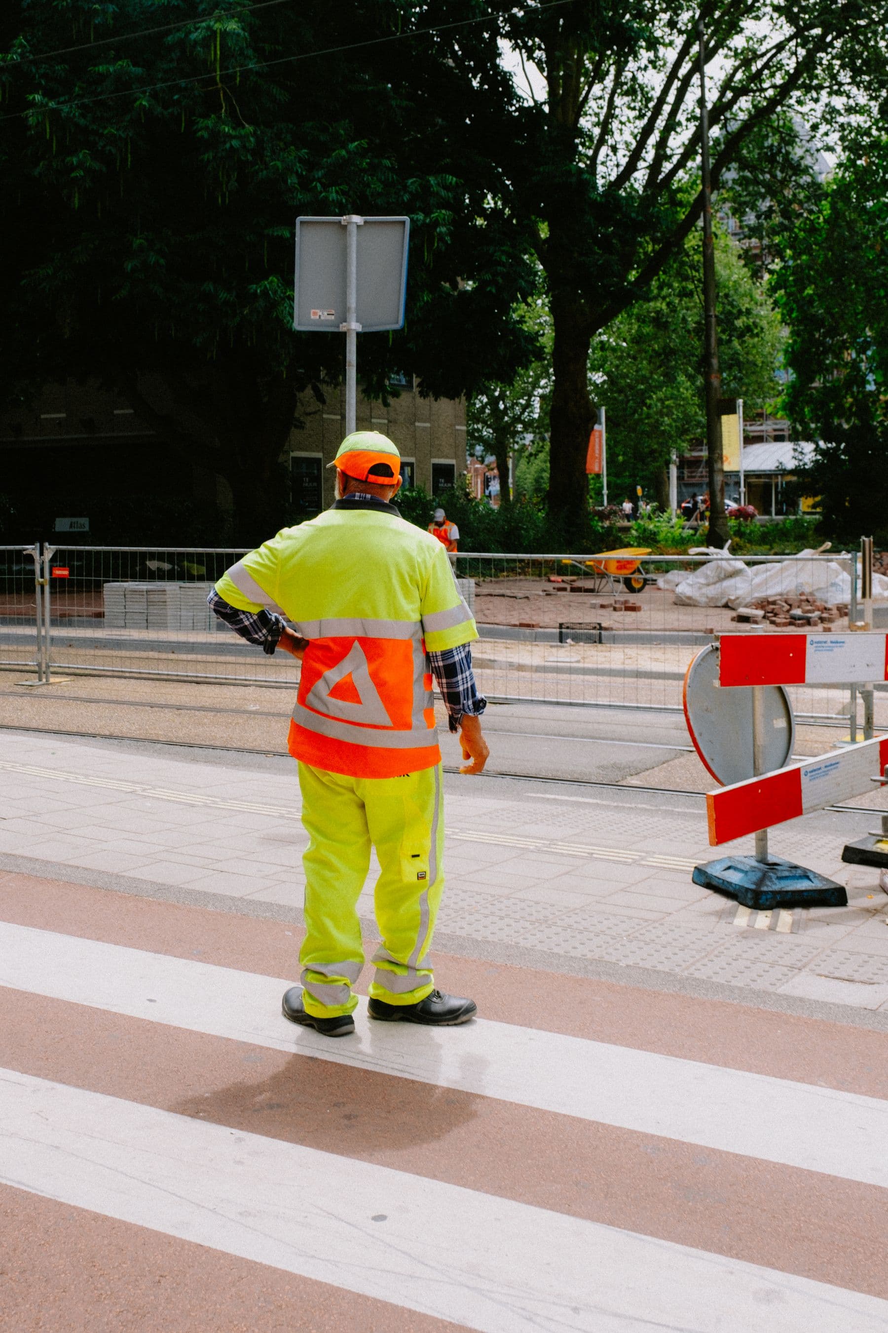 A worker in high-visibility clothing standing at a roadside site